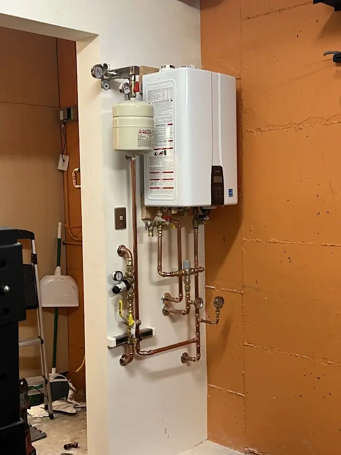 Plumbing technician inspecting water heater connections in Rose Hill